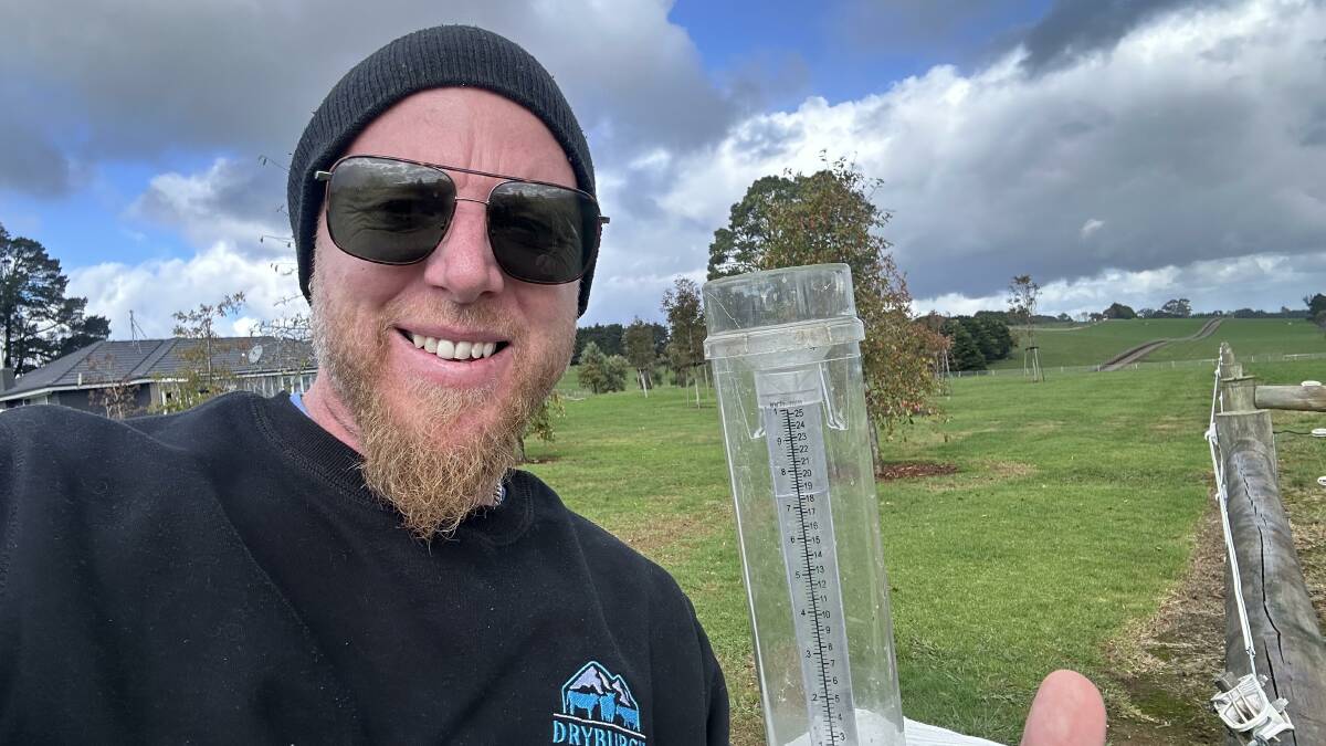 Neerim Junction farmer Ben Whiteley with his rain gauge, and paddocks that "look like a golf course". Picture supplied