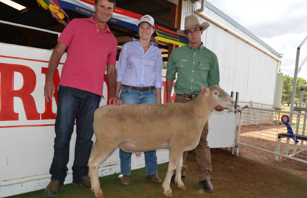 Equal top price: Angus and Kate McGeoch, Borambola with their equal top priced ram at $2000 held by Lamdmark, Wagga Wagga agent Hamish McGeoch. 