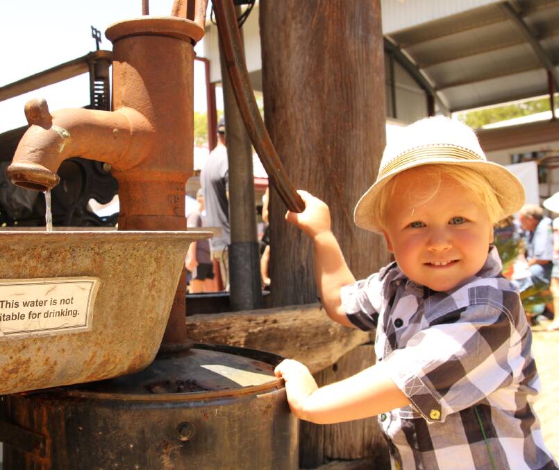 Flynn Sleeman, 3, Kuranda, works an original water pump on display at the Mareeba Heritage Centre celebrations.