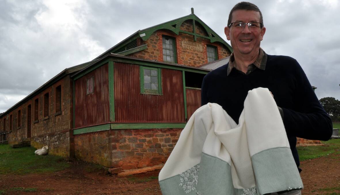 SA ICON: Anlaby Station's Andrew Morphett with one of their popular Tree of Life woollen throws outside the shearing shed built in 1871. The shed is still used today.