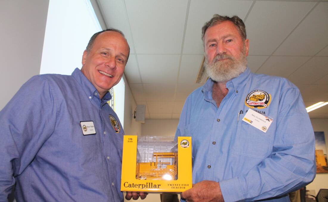 CATERPILLAR HERITAGE: Antqtiey Caterpillar Machinery Collectors Association (ACMOC) president Bruce Vinkler and Chapter Nineteen chairman Neil Clydsdale with some of the merchandise the club promotes.