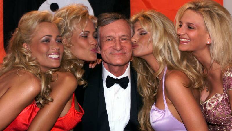 Playboy founder and editor in chief Hugh Hefner basks in the kisses of his playmates in Cannes, French Riviera in 1999. Picture: AP