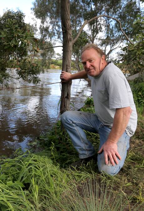 Wet days: Allansford resident Paul Richardson watches river levels.