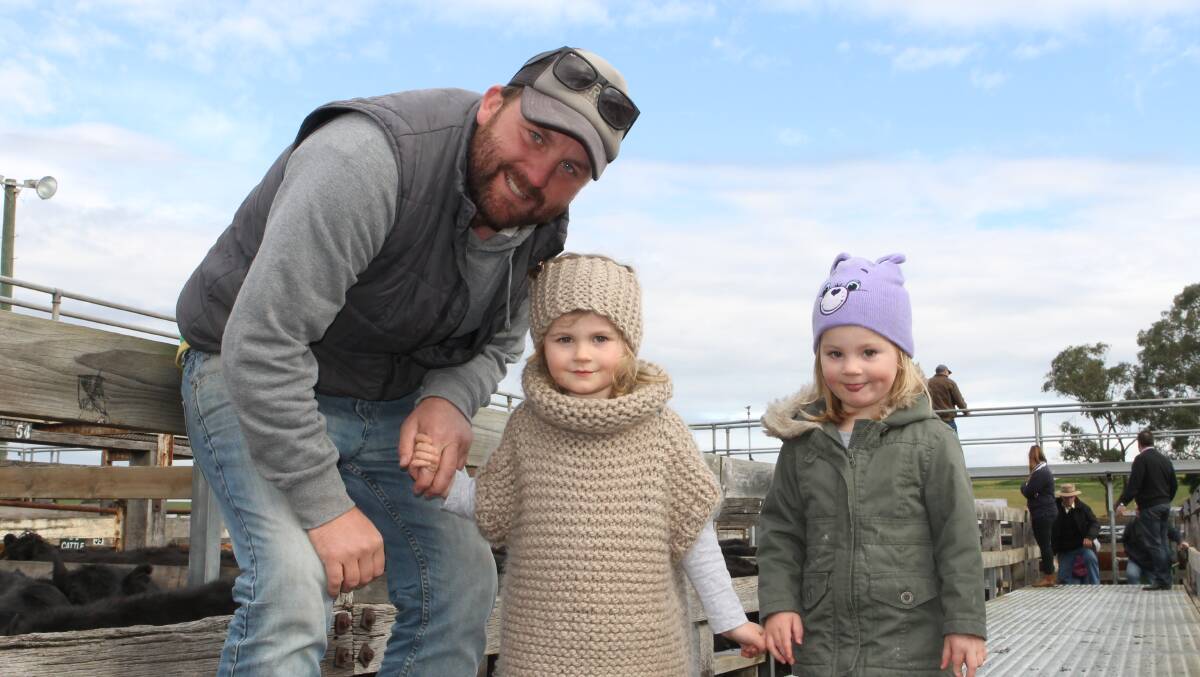 LITTLE ONLOOKERS: Chris Perry, Casterton, with daughters Stella, three, and Elle, two, at the Casterton store sale. Photo: Andrew Miller