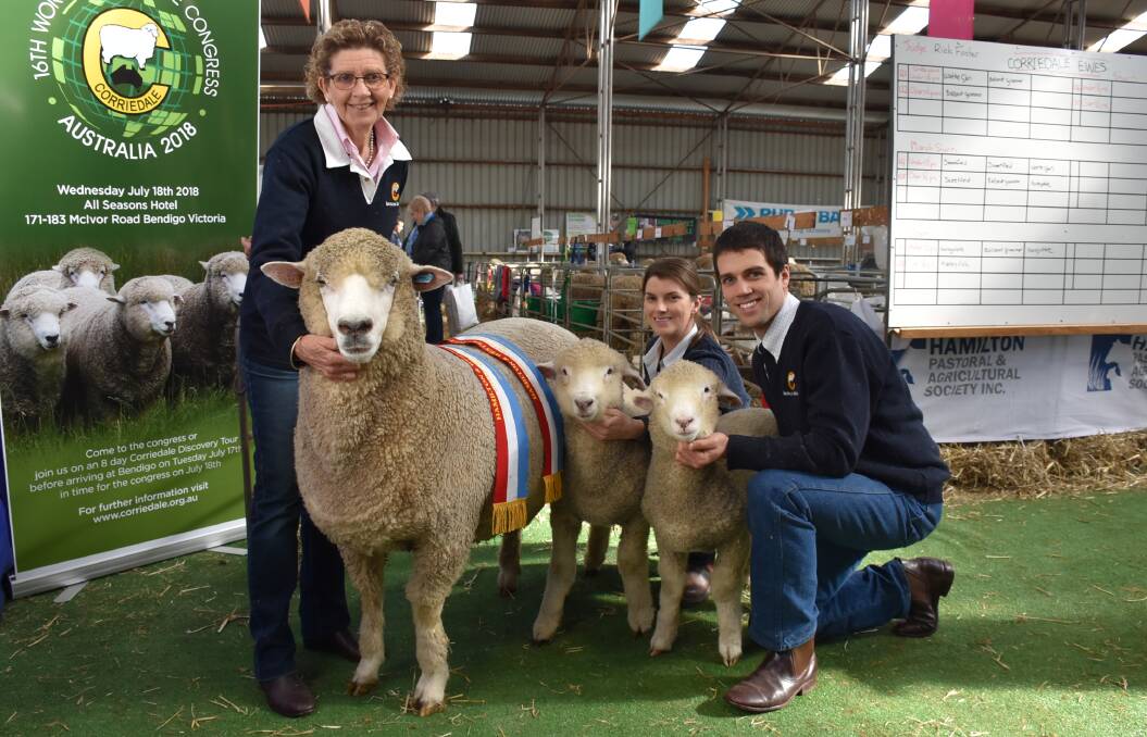 Bron Ellis, Casey Tomkins, and Leigh Ellis, Sweetfield, with their champion ewe and her two lambs at foot.