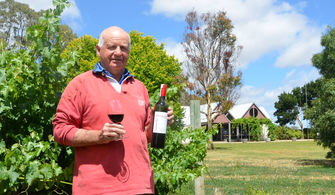 FORWARD THINKERS: Brian Smibert with the family's Whistle Post cabernet savignon 2012 in front of the cellar door-in-progress at Coonawarra.