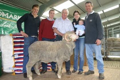 With Rock-Bank’s $20,000 ram were from left, stud workers Tim Meulendyks and Sam Crawford, Rock-Brank principal John Crawford, and buyers Victoria and Bradley Venning, with baby Samuel.