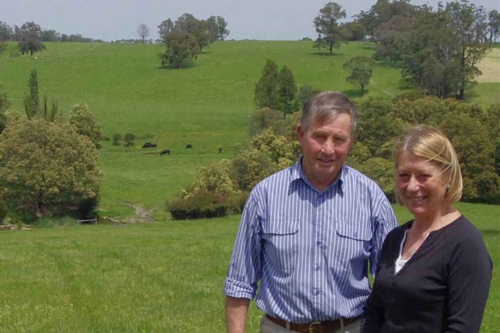 Peter and Jeanette Honey in the heifer paddock, which was the first block they purchased at Jarrahmond. Behind them is a confluence of waterways they have revegetated since 1996.