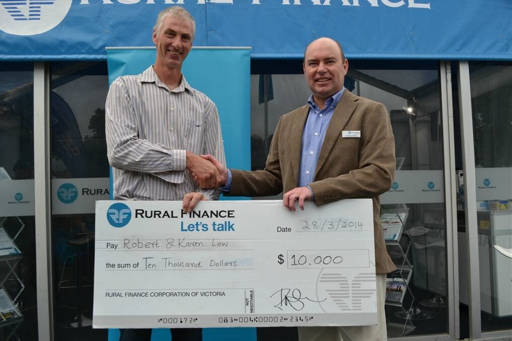 Gippsland dairy farmer Robert Low collecting his $10,000 prize from Rural Finance's Andrew Smith at Farm World on Friday.