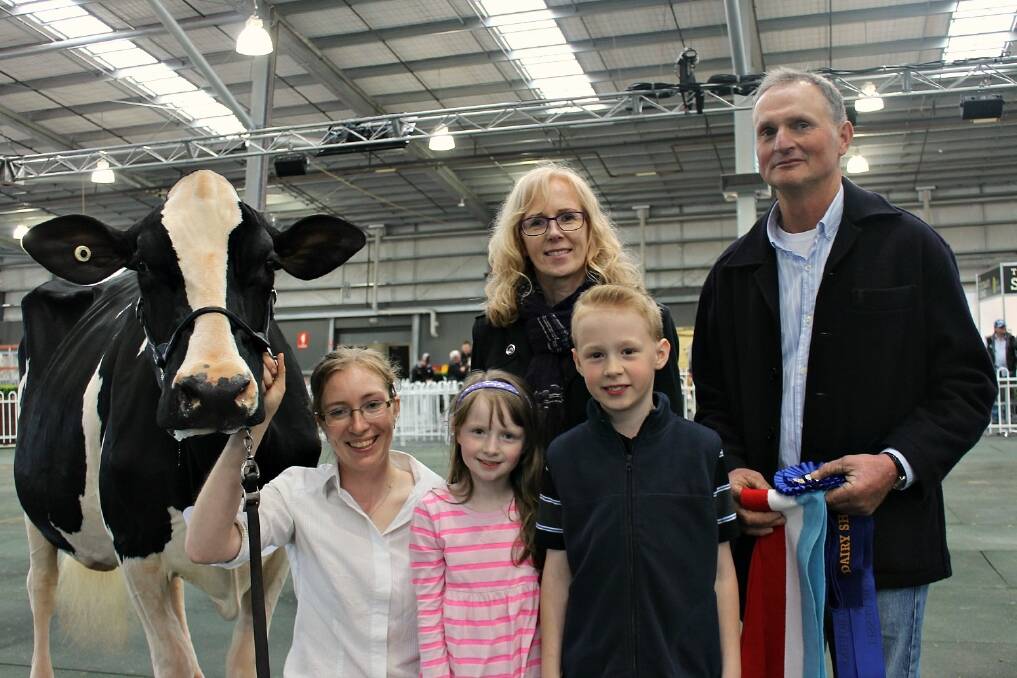 The supreme champion dairy exhibit, held by Alex Walker, Inverloch, and co-owners the Gardiner family including Cherie and John, and their kids Luke, 9 and Amy, 7.