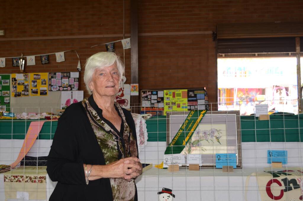 Shirley Breasley, retirng after 41 years as secretary of Holbrook Show admiring the Champion Exhibit in the pavilion - cros-stitch article made by Rebecca Prentice, Holbrook
