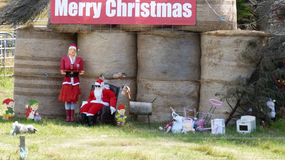 Jingle bells: Santa takes a 
spell in the shade of Gippsland 
hay bales, while preparing 
for his present run Christmas eve.