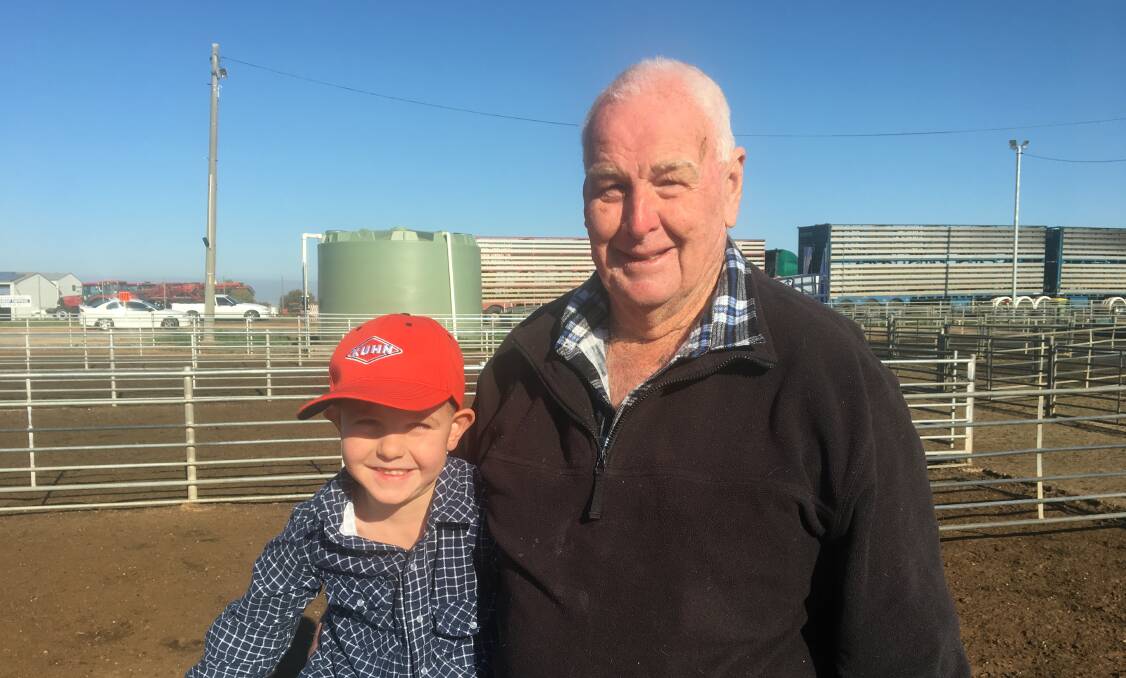 FAMILY: Keith Barber from Corowa with grandson Jackson Barber watching the sheep and lamb in Corowa on Monday. Although Corowa was closed for the long weekend, it was business as usual for this week.