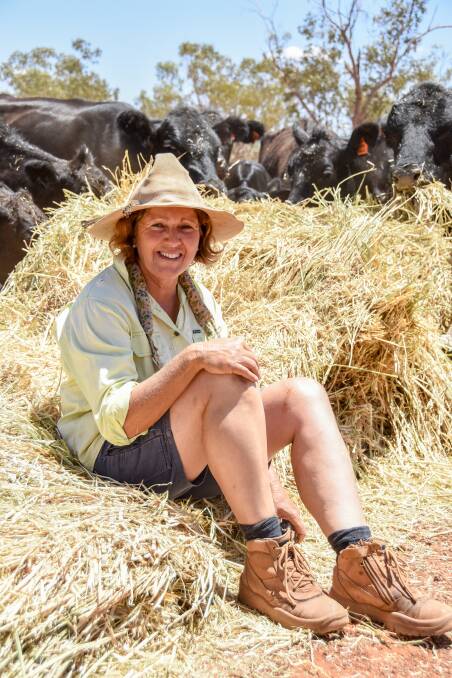 Mary Haig of Alroy at Eulo with some cattle enjoying food from the Hay Runners. Picture: Lucy Kinbacher