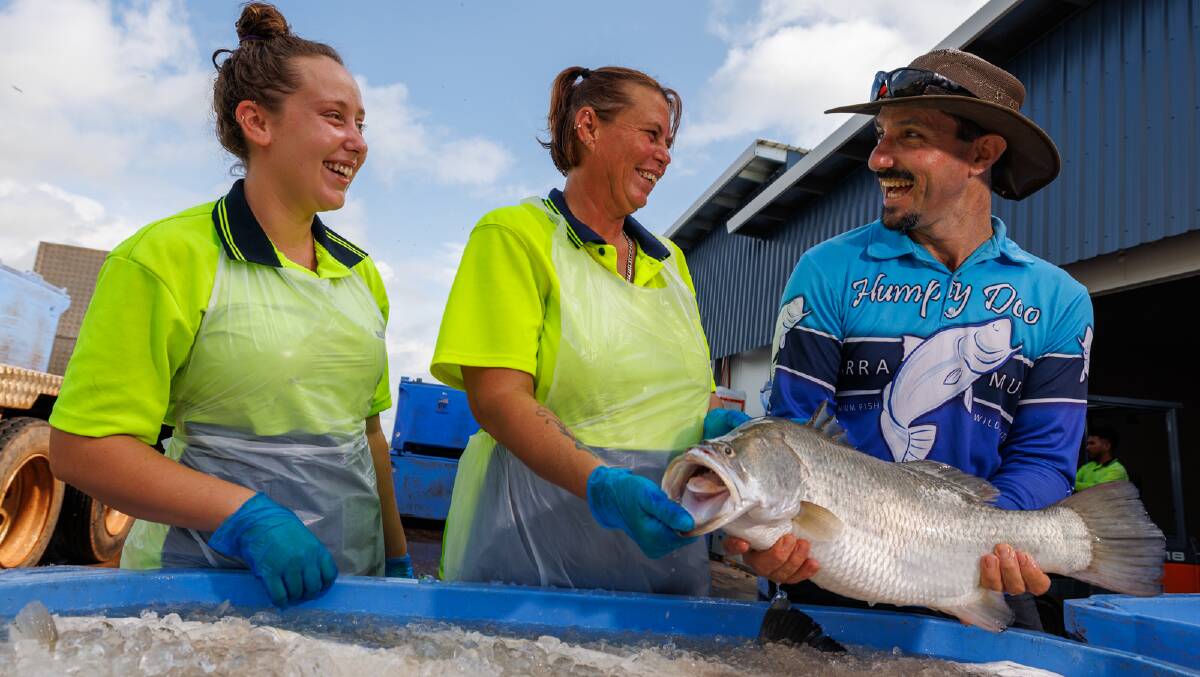 Humpty Doo Barramundi chief executive officer Dan Richards (right) holds a fish at their NT operation. Picture supplied. 