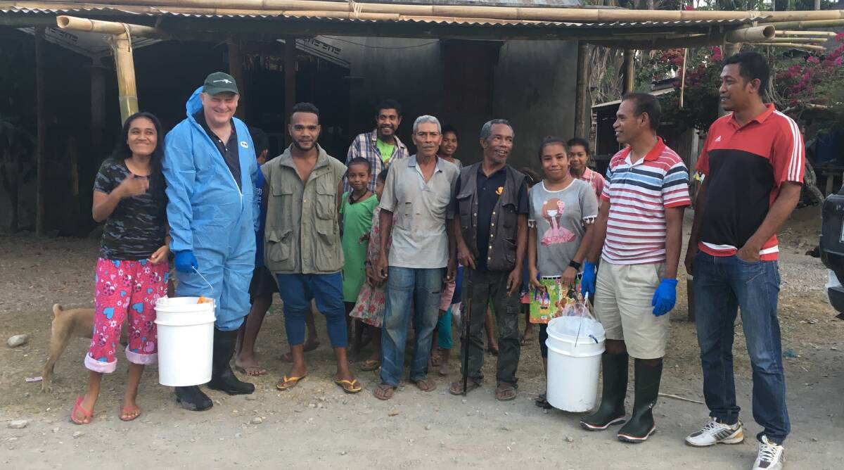 Agriculture Victoria research leader Grant Rawlin (in blue) in Timor-Leste working with Timorese farmers, vets and animal health staff. Photo supplied