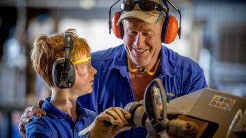 Parents should always supervise children when working on the farm. Pictured is Peter Thompson and son Luke in the workshop on their farm at Manangatang. Photo: Supplied.