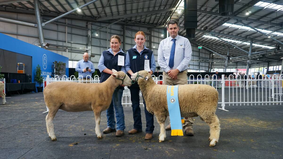 Cheyenne Tucker and Erin Chesworth, Finley High School, and Poll Dorset judge Nick Lawrence, Bordertown, SA, with the grand champion ewe and supreme champion ram. Picture by Rachel Simmonds