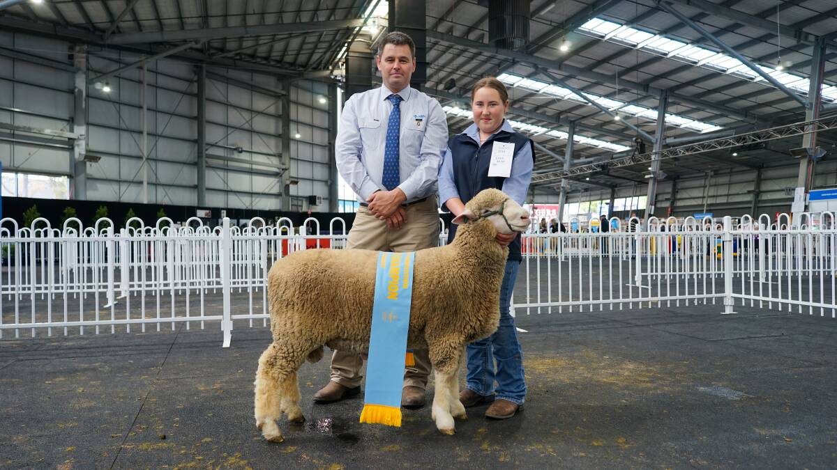 Poll Dorset judge Nick Lawrence and Finley High School Year 10 student Cheyenne Tucker, with the supreme champion ram. Picture by Rachel Simmonds