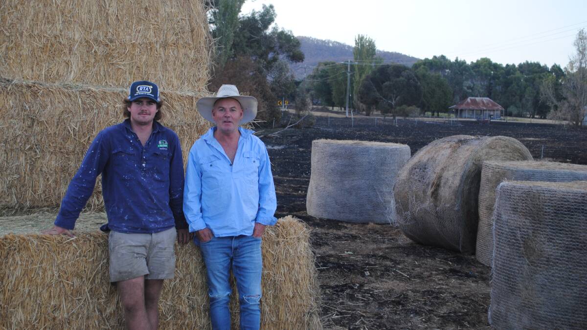 Angus and David Troup, Raglan, with fodder donated by farmers following the bushfire. Picture by Barry Murphy 