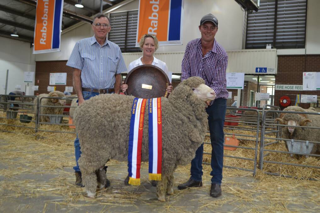 Mikala Walters presenting the Sid and Bob Walters Memorial for champion sale ram to Ron and Aaron Granger, Rogara Poll Merinos, Goulburn.