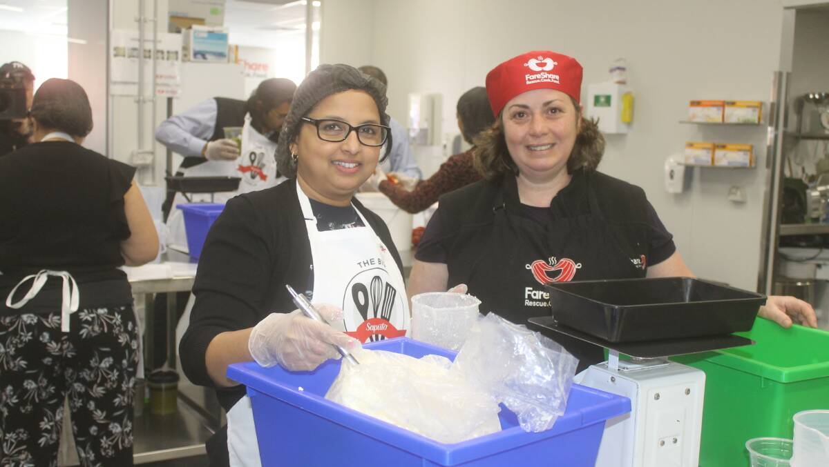 NOVEMBER HELP: Saputo Dairy Australia has continued its community supporrt, this time through bushfire relief donations. In November staff, including Indukala Kuaiyil, here being given a helping hand by FairShare's Kellie Watson, helped cook meals for the charity.. 