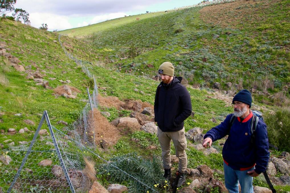 [LAND SURVEY: Community members and land managers Neil Devanny and Tom Miller discussing weeds and rabbits at an event near Werribee.
