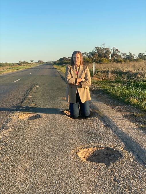 Jade Benham MP knee deep in potholes on the Robinvale-Sea Lake Road. Picture supplied by Jade Benham