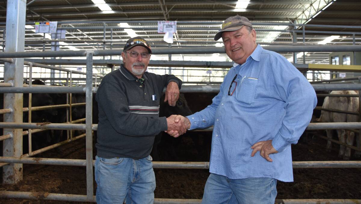SHAKE ON IT: Kevin Ryan, Darraweit Guim, with successful bidder, Perry Jarvis, Yarra Glen, at the Yea monthly store sale.