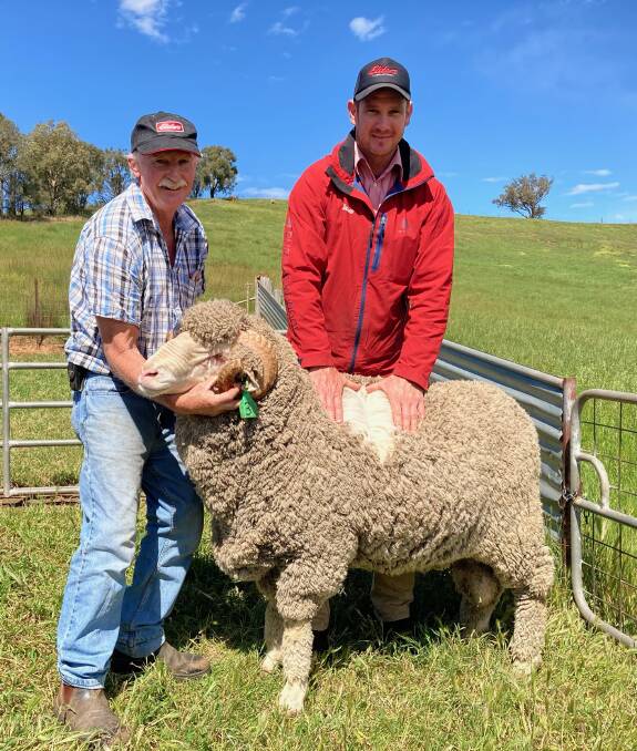 SON OF A GUN: Murray McKenzie and Rex Bennett, Elders with the top priced ram, which went to a Riverina buyer.
