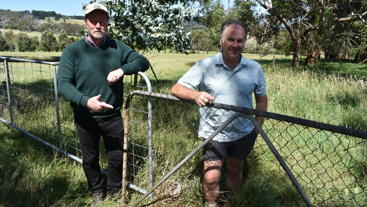 Victorian Farmers Federation Mornington Peninsula branch president Stephen Todd and shire mayor Simon Brooks with a gate damaged by kangaroos. Picture by Andrew Miller