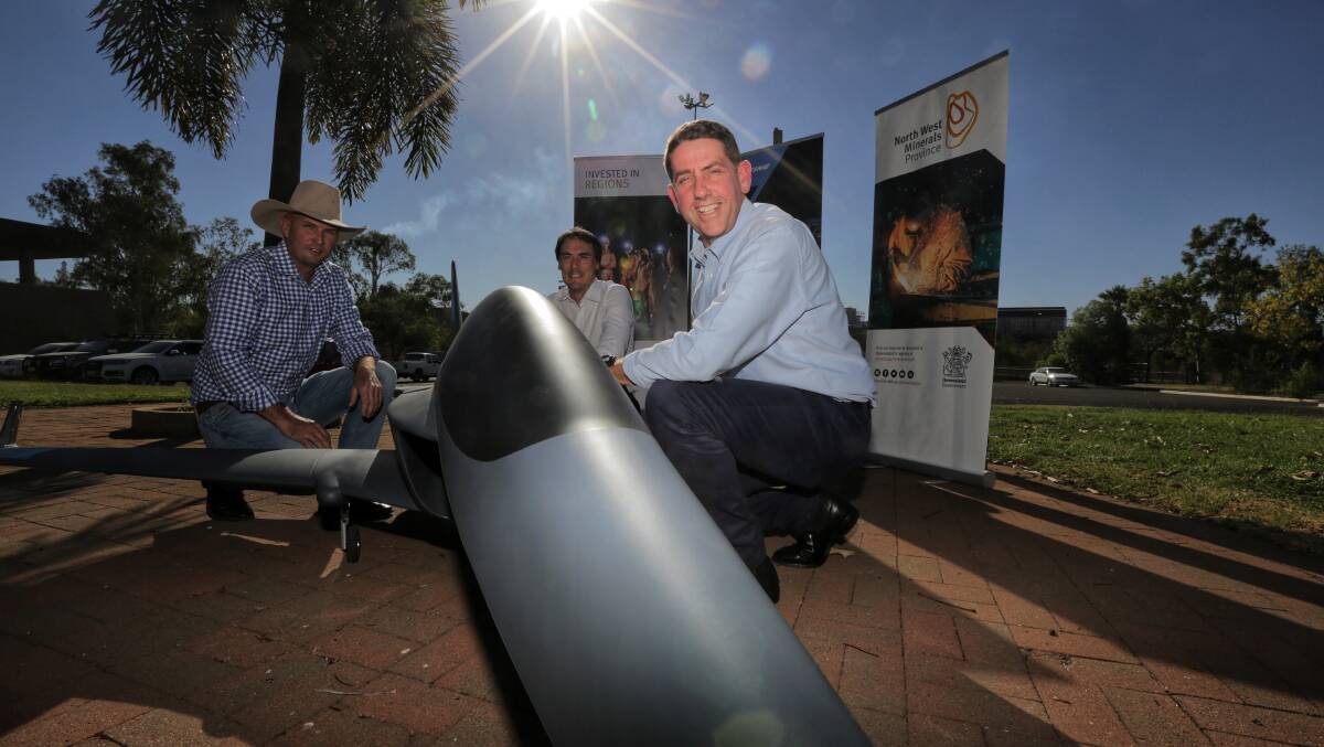 Cloncurry mayor Greg Campbell, Boeing's senior manager experimentation Rob Hargrave and state development minister Cameron Dick with an example of a drone that could be tested at Cloncurry's new facility. 