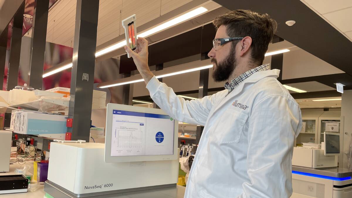Illumina laboratory programs manager Will Grant checks a flow cell used to sequence animal samples in the Melbourne lab. Picture by Bryce Eishold