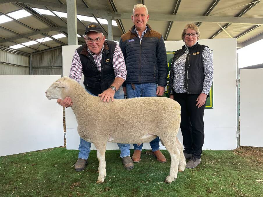 HEADING WEST: The top-priced ram, Lot 16 Waratah 200661, with Waratah White Suffolk stud principals Steve and Debbie Milne and auctioneer Bernie Grant, LMB Livestock and Land (middle).