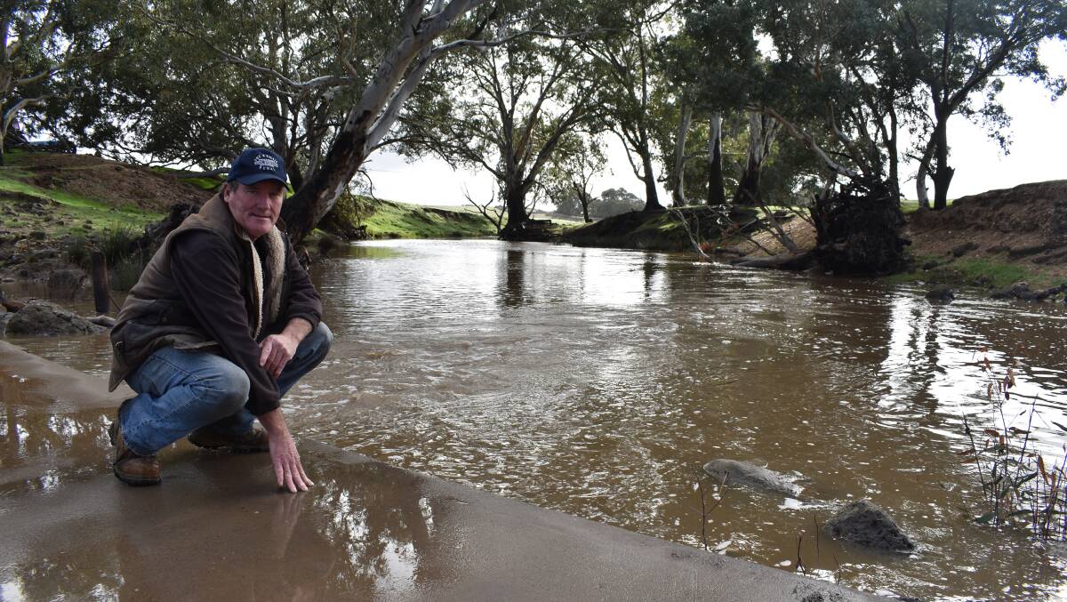 FLOWING: Brendan Roughead checks the flow of water in McCallums Creek on his property at Craigie north of Ballarat. The creek had been dry up until four weeks ago but had been boosted by 140mm of rain in May and another 32mm in June. Photo by Alastair Dowie.