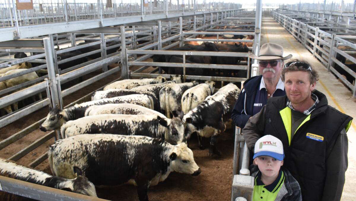Happy: Buyer, Snow Merrett (back), Penola, SA, with vendor Paul Riches and sonFlynn, The Sisters, with the pen that made 374c/kg or $1402.50 at the Western District Livestock Exchange on Thursday.