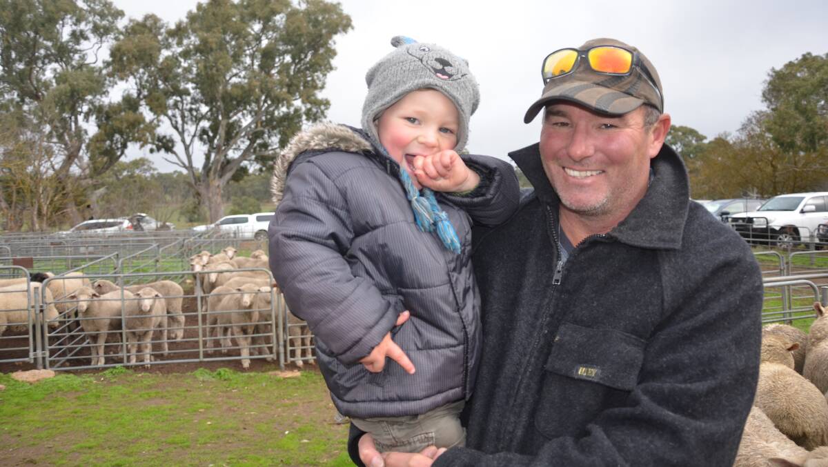 SELLING: Danny Pauley, Kenton Valley, SA, with son Mostyn, 2, sold 18 Dohne/Merino-cross wethers and lambs and one Dohne ram at Mount Pleasant, SA.