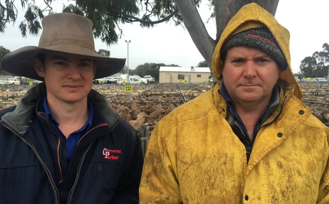 WET CONDITIONS: James Cleeland from Corcoran Parker Mansfield with Brocklesby's Richard Koschitzke, who sold 230 ewes to a top of $125.20 at Corowa, where lamb numbers were similar to last week.