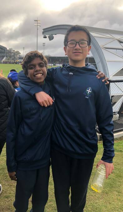 Boarding Buddies: Dwayne Hayes and Eric Yang, who have formed a bond in their time as Year 7 boarders, attend an AFL match.