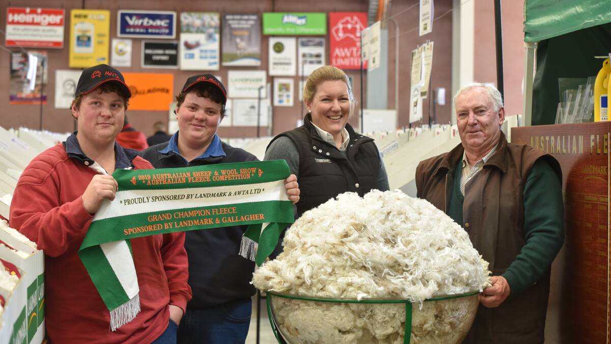 FAMILY AFFAIR: Darren, William and Stephen Glen, Wattle Bank Merino stud, with Australian Fleece Competition convener Candice Cordy, Nutrien (second from right), and the champion fleece from the 2019 competition. Photo by Ruby Canning.