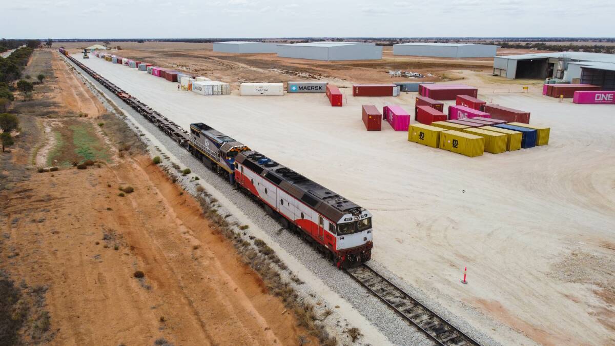 Containers are lifted onto a train waiting just a few hundred metres from the Mallee Hay processing facility and destined for the Melbourne Port.