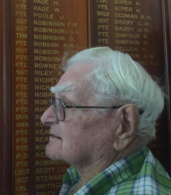 Trevor Brooker stands before the honour roll in the Dungog Memorial RSL Club. 
