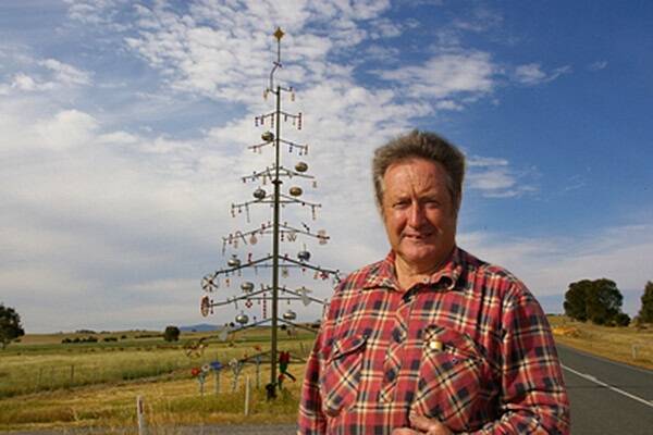 Clive Keays with his 13-metre high xmas tree that lights up at night when cars drive past with their high beams on.