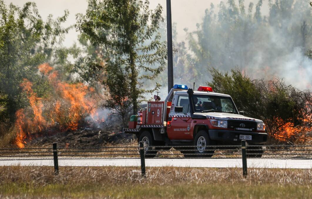 A NSW Rural Fire Service crew tackling a fire on the side of the Hume Highway at Albury on January 10. The fire was sparked by a train. 