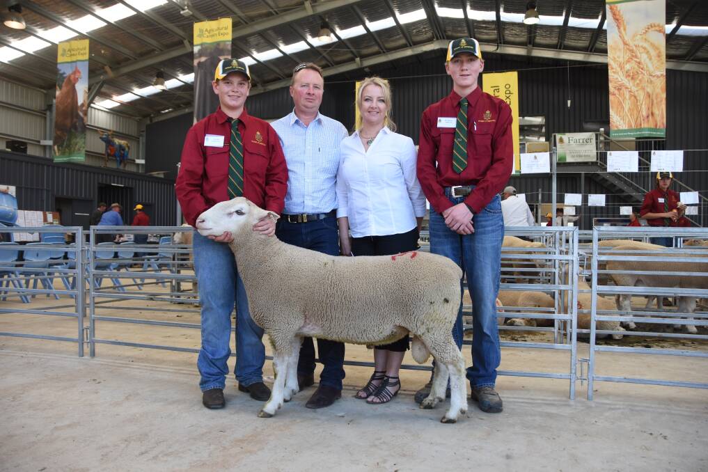 Farrer High School students Joseph Ticehurst and Brandon Andrews (red shirts) with top price ram buyers Craig Mitchell and Philippa Jordan-Hill, Gemini Prime Lamb Sires, Wernith, Victoria, and the $9100 White Suffolk sale topper. 